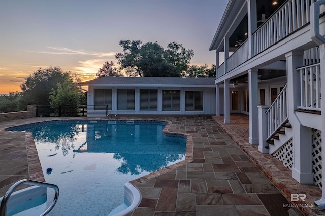 pool at dusk featuring a patio area and french doors