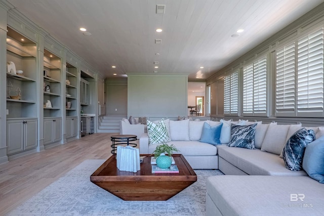 living room with plenty of natural light, light hardwood / wood-style floors, and built in features