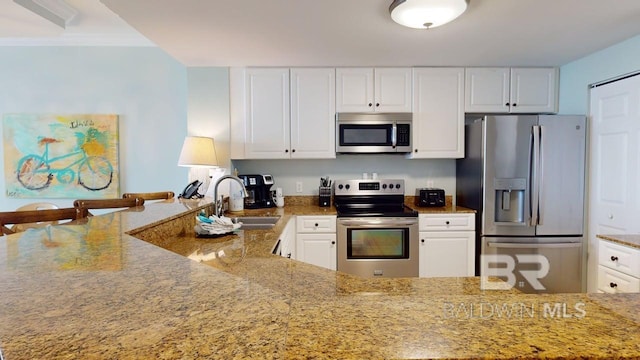 375 Beach Club Trl Unit A-1608, Gulf Shores, AL 36542 - kitchen featuring appliances with stainless steel finishes, a sink, light stone counters, white cabinetry, and crown molding