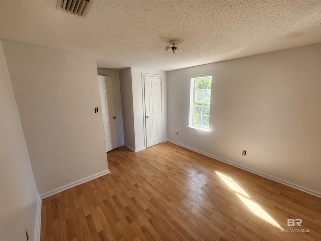 unfurnished bedroom featuring a textured ceiling and light wood-type flooring