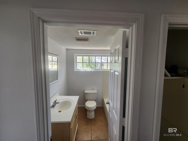 bathroom with tile patterned floors, vanity, toilet, and a textured ceiling