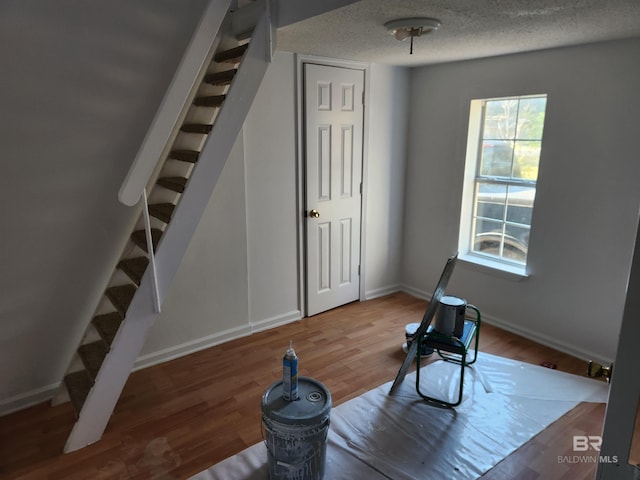 workout area featuring wood-type flooring and a textured ceiling