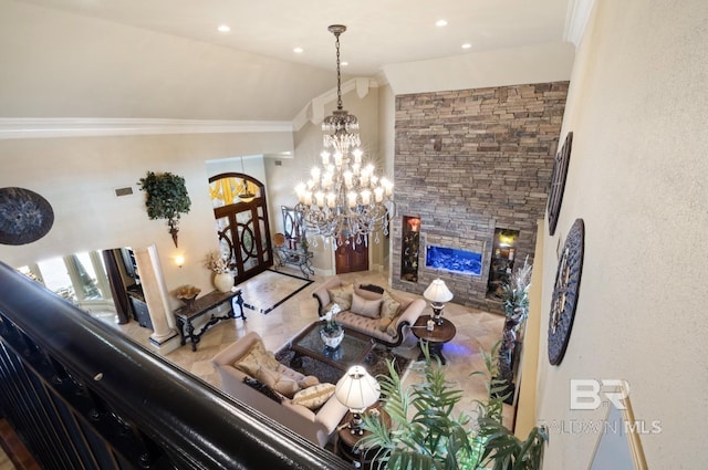 living room with ornamental molding, vaulted ceiling, a chandelier, and a fireplace