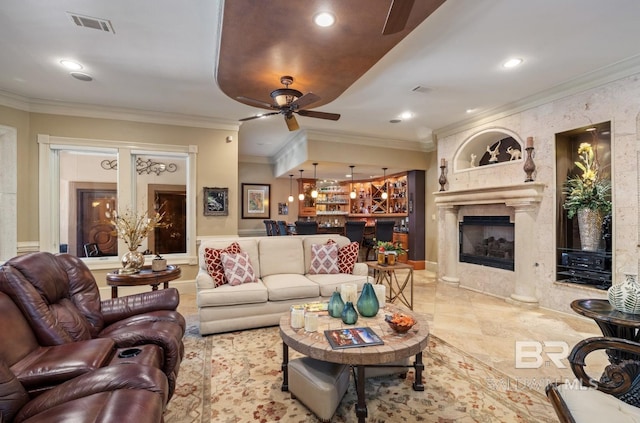 living room featuring crown molding, ceiling fan, and a high end fireplace