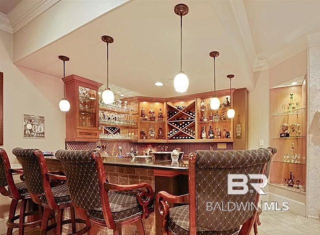 bar with pendant lighting, ornamental molding, and light tile patterned flooring