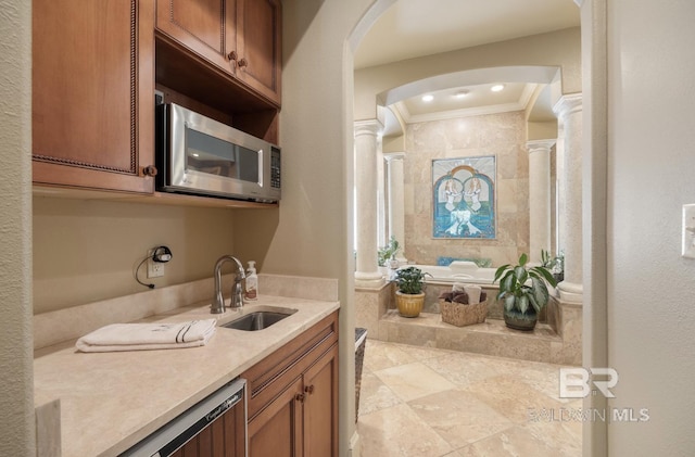 bathroom featuring crown molding, vanity, a relaxing tiled tub, and ornate columns