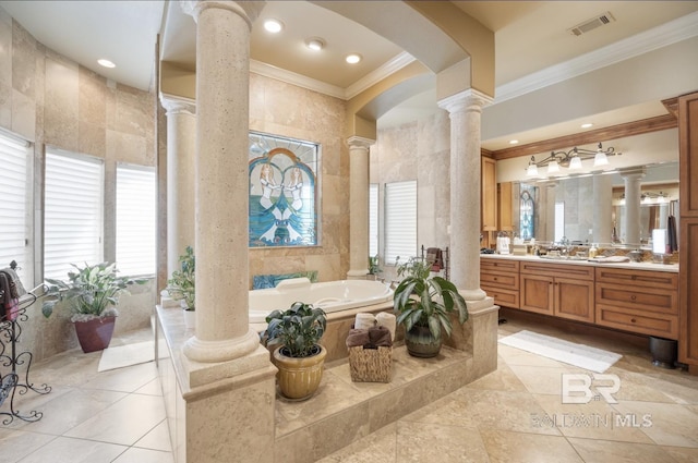 bathroom featuring tiled tub, crown molding, tile walls, vanity, and ornate columns