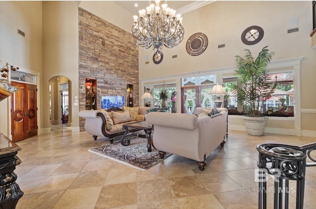 living room with ornamental molding, a healthy amount of sunlight, a chandelier, and a high ceiling