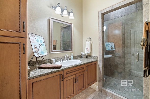 bathroom with vanity, tile patterned floors, and a shower with door