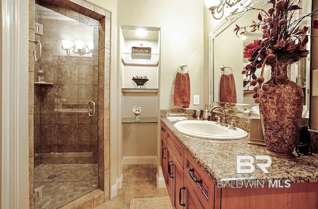 bathroom with vanity, a shower with shower door, and tile patterned floors