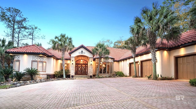 mediterranean / spanish-style home with a garage