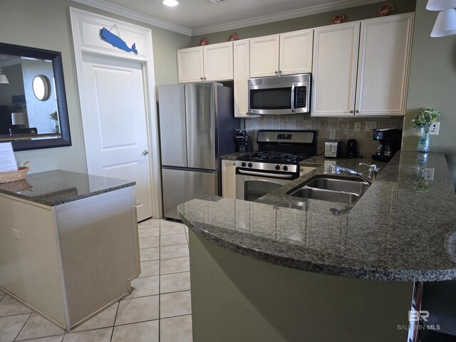 kitchen with white cabinetry, sink, dark stone countertops, kitchen peninsula, and stainless steel appliances