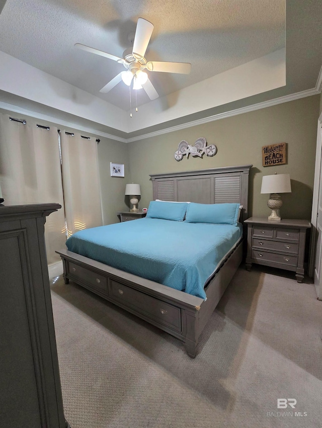 bedroom with ceiling fan, light colored carpet, a textured ceiling, and a tray ceiling