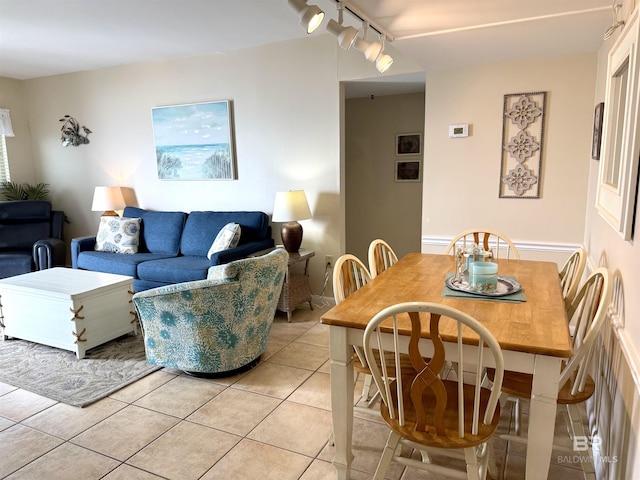 dining area with light tile patterned floors and rail lighting