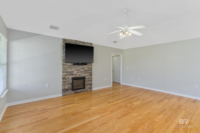 17570 Driskell Rd, Loxley, AL 36551 - unfurnished living room featuring light wood-style flooring, a stone fireplace, ceiling fan, and lofted ceiling