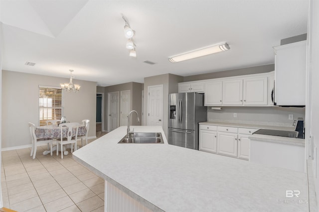17570 Driskell Rd, Loxley, AL 36551 - kitchen with stainless steel fridge with ice dispenser, range, light tile patterned floors, a chandelier, and white cabinetry