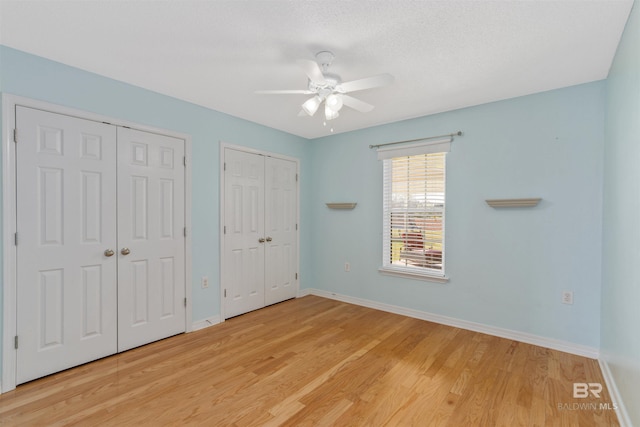 17570 Driskell Rd, Loxley, AL 36551 - unfurnished bedroom with multiple closets, light wood-type flooring, and ceiling fan