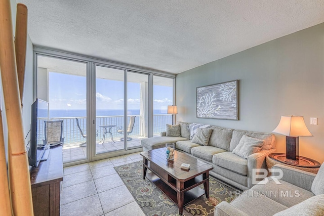 521 W Beach Blvd Unit 2102, Gulf Shores, AL 36542 - living room with healthy amount of natural light, a wall of windows, a textured ceiling, and light tile patterned floors