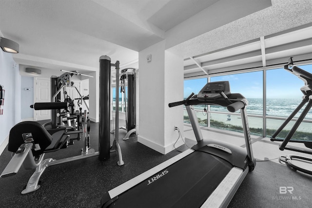 521 W Beach Blvd Unit 2102, Gulf Shores, AL 36542 - workout area featuring a water view, healthy amount of natural light, beam ceiling, and baseboards
