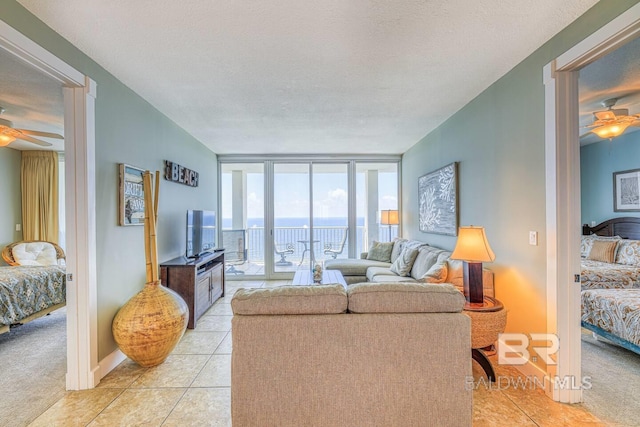 521 W Beach Blvd Unit 2102, Gulf Shores, AL 36542 - living room with a ceiling fan, floor to ceiling windows, light tile patterned floors, light colored carpet, and a textured ceiling