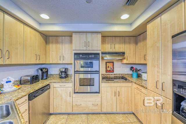 521 W Beach Blvd Unit 2102, Gulf Shores, AL 36542 - kitchen with light brown cabinets, under cabinet range hood, stainless steel appliances, light stone countertops, and light tile patterned floors