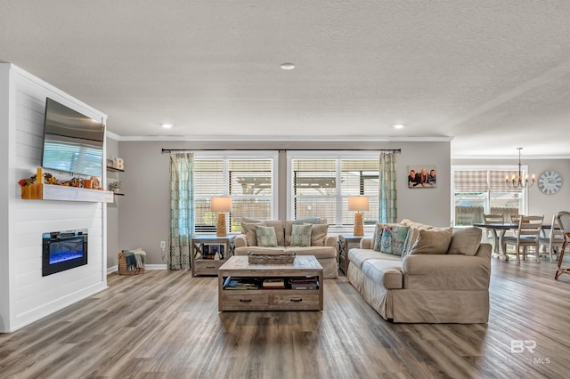 22310 Early Dawn Cir, Foley, AL 36535 - living area featuring crown molding, plenty of natural light, wood finished floors, and a notable chandelier