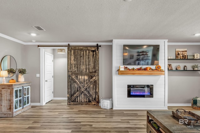 22310 Early Dawn Cir, Foley, AL 36535 - interior space featuring crown molding, a barn door, a textured ceiling, and wood finished floors