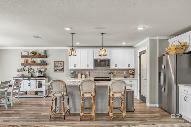 22310 Early Dawn Cir, Foley, AL 36535 - kitchen with light countertops, white cabinetry, appliances with stainless steel finishes, and ornamental molding