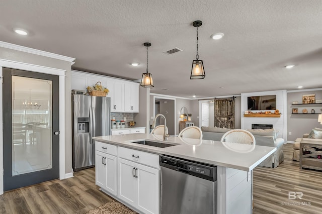 22310 Early Dawn Cir, Foley, AL 36535 - kitchen featuring a sink, light countertops, stainless steel appliances, open floor plan, and wood finished floors