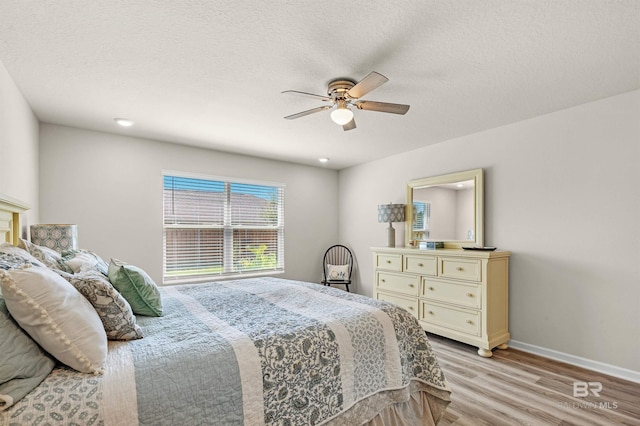 22310 Early Dawn Cir, Foley, AL 36535 - bedroom with a textured ceiling, baseboards, ceiling fan, and light wood-type flooring