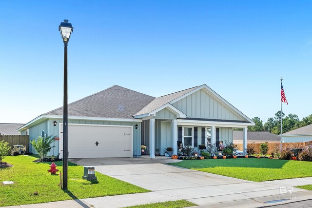 22310 Early Dawn Cir, Foley, AL 36535 - view of front of home with a garage, a front lawn, fence, a shingled roof, and board and batten siding