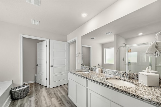 22310 Early Dawn Cir, Foley, AL 36535 - bathroom with visible vents, double vanity, wood finished floors, a sink, and a stall shower