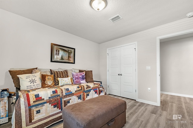 22310 Early Dawn Cir, Foley, AL 36535 - living area featuring baseboards, light wood finished floors, a textured ceiling, and visible vents