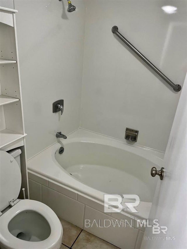 bathroom featuring tile patterned floors, tiled shower / bath combo, and toilet