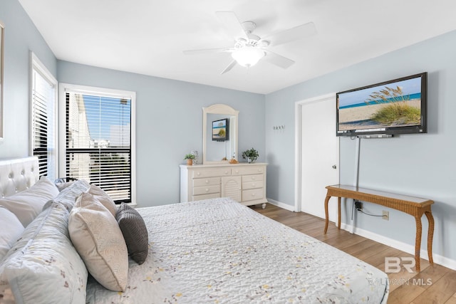 bedroom featuring wood finished floors, a ceiling fan, and baseboards