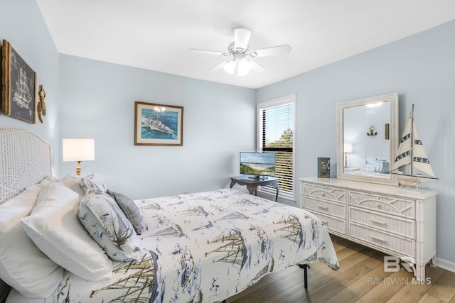 bedroom featuring wood finished floors, a ceiling fan, and baseboards