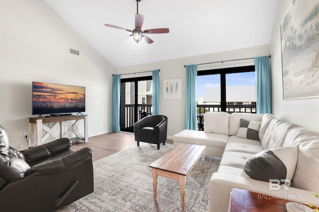 living room with visible vents, baseboards, ceiling fan, wood finished floors, and high vaulted ceiling