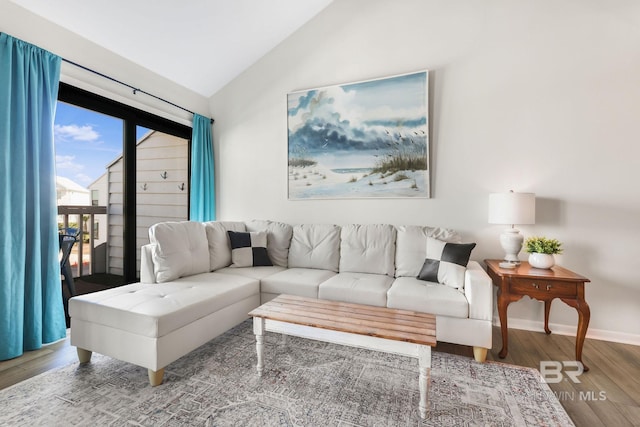 living area featuring baseboards, vaulted ceiling, and wood finished floors