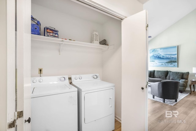 laundry area with laundry area, separate washer and dryer, and light wood-style flooring