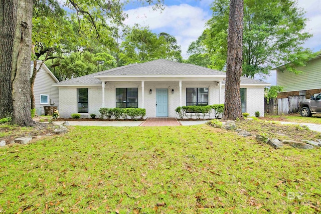 single story home featuring a porch, a front lawn, brick siding, and roof with shingles