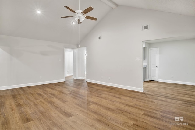 unfurnished living room featuring a ceiling fan, high vaulted ceiling, beamed ceiling, baseboards, and wood finished floors
