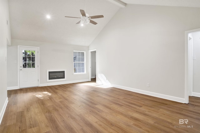 unfurnished living room with high vaulted ceiling, a ceiling fan, baseboards, beam ceiling, and a glass covered fireplace