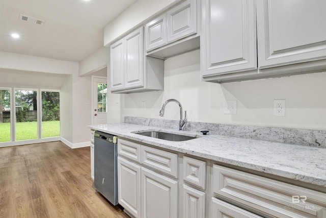 kitchen with dishwasher, a sink, light wood-type flooring, white cabinets, and baseboards