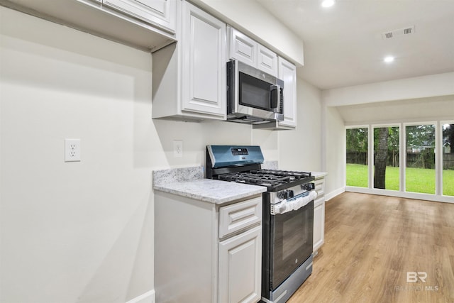 kitchen featuring stainless steel appliances, baseboards, white cabinetry, light wood-type flooring, and recessed lighting