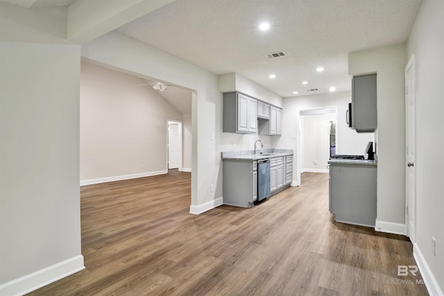 kitchen with gray cabinetry, stainless steel dishwasher, recessed lighting, wood finished floors, and baseboards