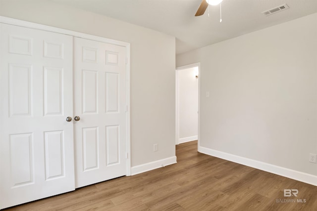 unfurnished bedroom featuring light wood finished floors, baseboards, a closet, and a ceiling fan