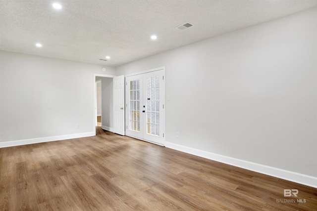 spare room featuring recessed lighting, french doors, baseboards, and wood finished floors
