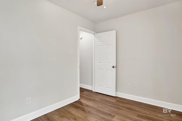 empty room with baseboards, wood finished floors, and a ceiling fan