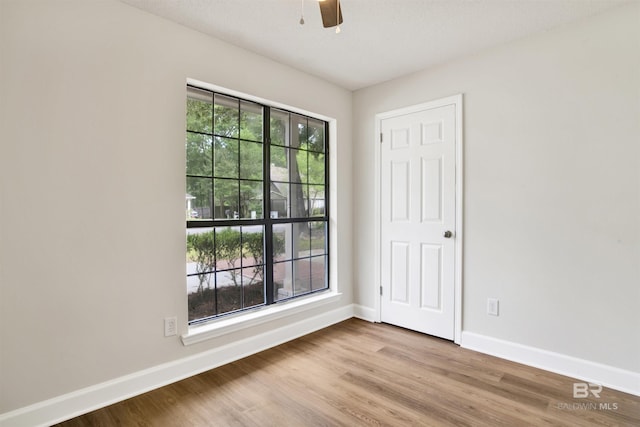 unfurnished room featuring baseboards, a ceiling fan, and wood finished floors