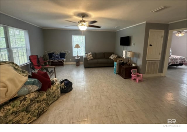 living room featuring ceiling fan, crown molding, and a healthy amount of sunlight